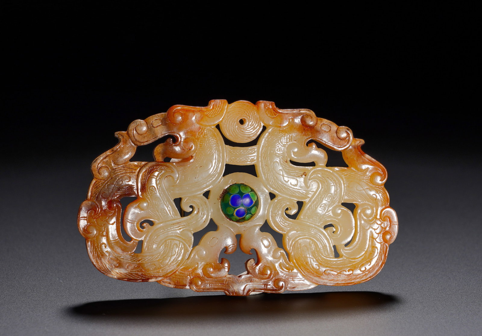 HAN DYNASTY HETIAN JADE PENDANT WITH DOUBLE DRAGON PATTERNS: Height:4.7cm(1.85in) Width:7.7cm(3.03in) Weight:40g(0.09lb)Oval jade ornament carved with confronting dragon pair enclosing central glass pearl. Dragon symbolizes supreme auspicious beast. It served a