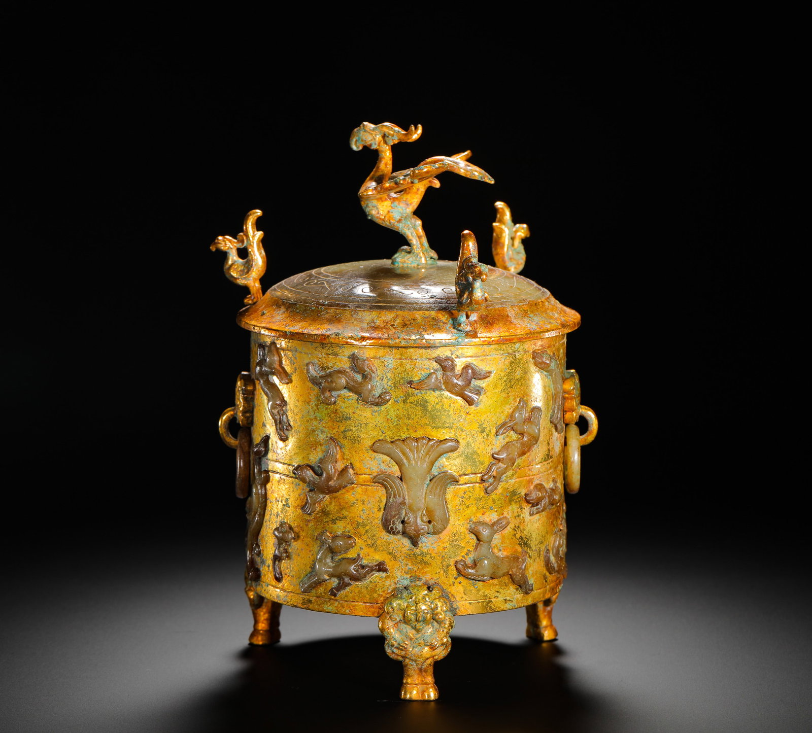 A GILDED BRONZE JAR WITH JADE INLAID AUSPICIOUS BEAST PATTERN FROM THE HAN DYNASTY: Height:20cm(7.87in) Width:13cm(5.12in) Weight:1620g(3.57lb)Han Dynasty gilt bronze three-legged covered zun inlaid with jade mythical beast patterns. The bronze vessel is fully gilded, with carved jad