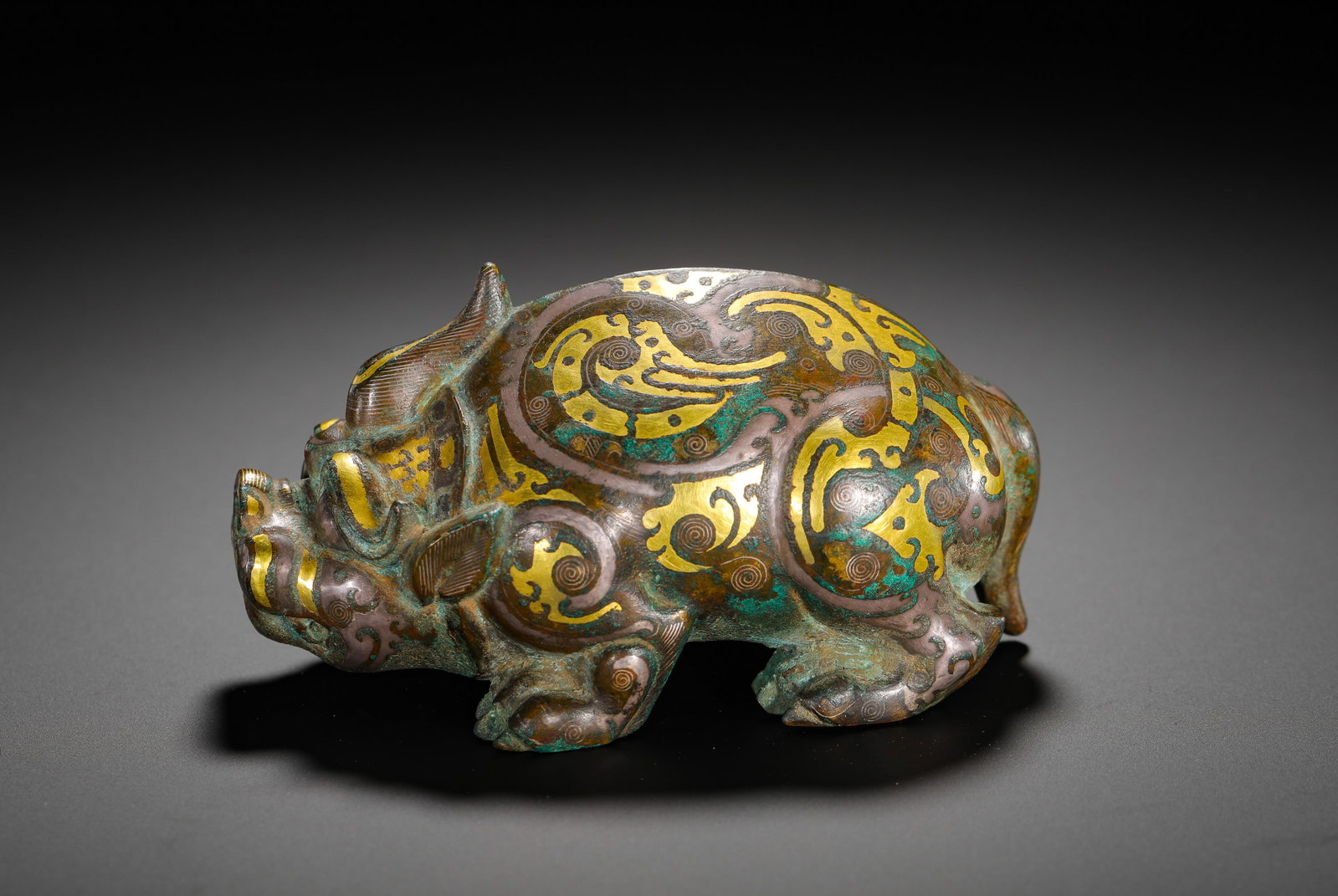BRONZE INLAID GOLD AND SILVER UNICORN-HORNED AUSPICIOUS BEAST FROM THE WARRING STATES PERIOD