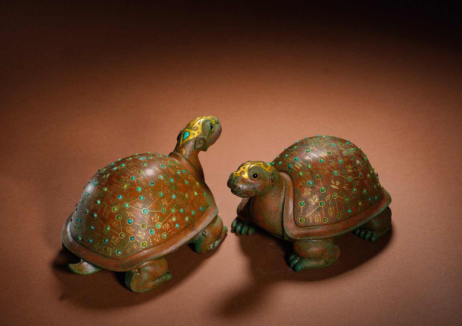 BRONZE INLAID GOLD INLAID TURQUOISE ASTRONOMICAL TURTLE-SHAPED TOWN FROM THE WARRING STATES PERIOD: Height:9cm(3.54in) Width:16.5cm(6.50in) Weight:1560g(3.44lb)Cast in bronze as a matched set of recumbent tortoises. Star charts and inscriptions are outlined with gold wire on shells, with turquoise i