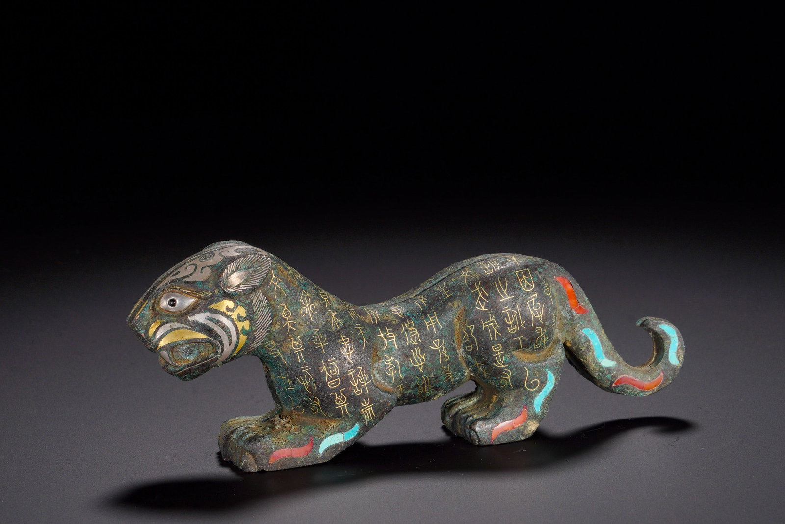 HAN DYNASTY INLAID GOLD INSCRIPTION MILITARY TOKEN: Height:6cm(2.36in)Width:15.5cm(6.10in)Weight:740g(1.63lb)The striding tiger bears imposing vigor. Its face is decorated with gold and silver inlay, eyes inlaid with white stone, limbs adorned with col