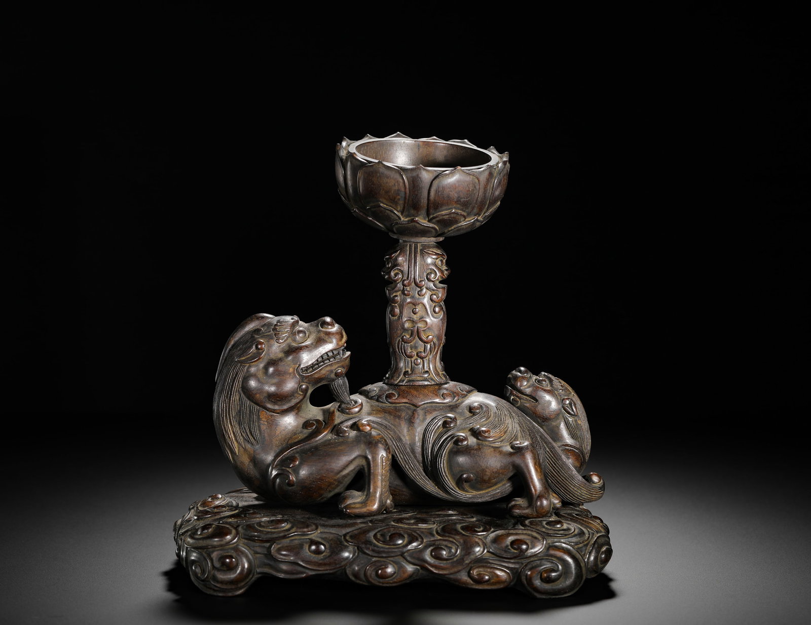 FLOWER VASE CARVED FROM ROSEWOOD OF THE QING DYNASTY: Height:21cm(8.27in) Width:21cm(8.27in) Weight:1280g(2.82lb)Qing Dynasty rosewood flower vase carved with grand lion and cub bearing lotus cup, fully round-carved from a single rosewood block. The moth
