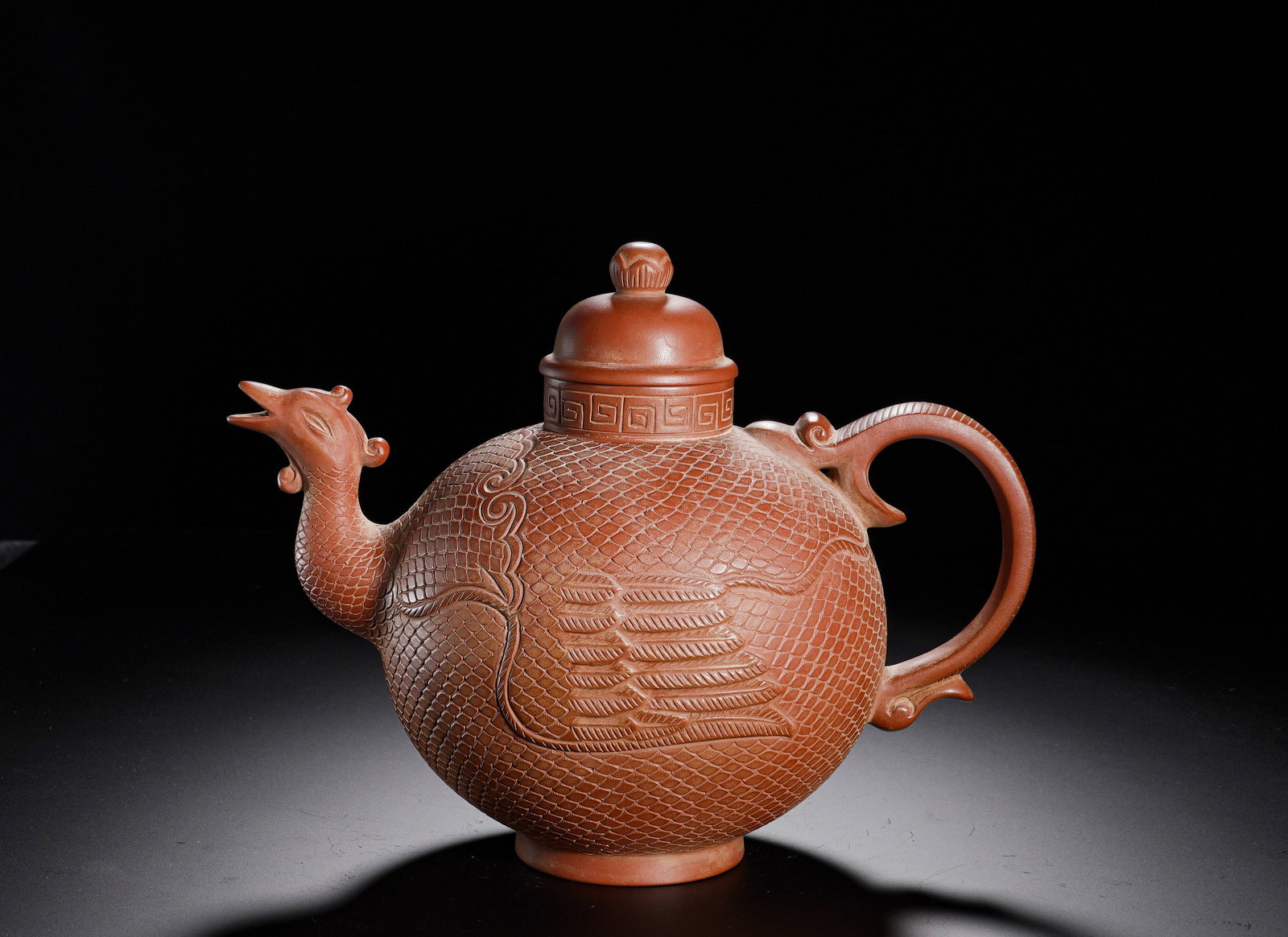CHEN MINGYUAN PURPLE CLAY TEAPOT: Height:17cm(6.69in), Width:23cm(9.06in), Weight:790g (1.742lb)Phoenix-shaped zisha teapot. Fully decorated with carved fish scales and phoenix feather relief. Spout modeled as phoenix head, handle sha