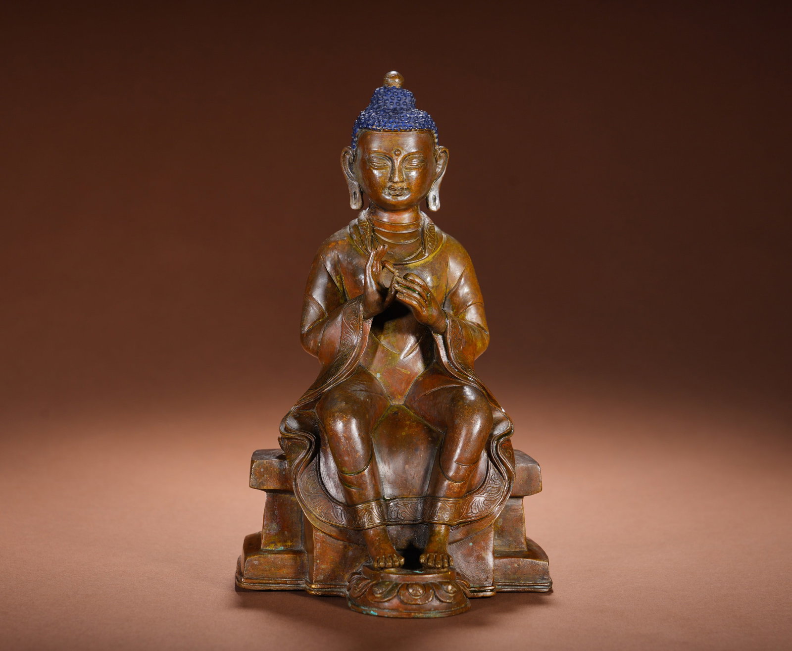 BRONZE LAMP BUDDHA CROSS-LEGGED SITTING FIGURE OF THE QING DYNASTY: Height: 22cm(8.66in), Width: 13cm(5.12in), Weight: 1890g (4.167lb)Cast in pure bronze with mellow aged patina, the Buddha??s spiral hair is painted blue. He holds Vitarka Mudra at chest level, seated 