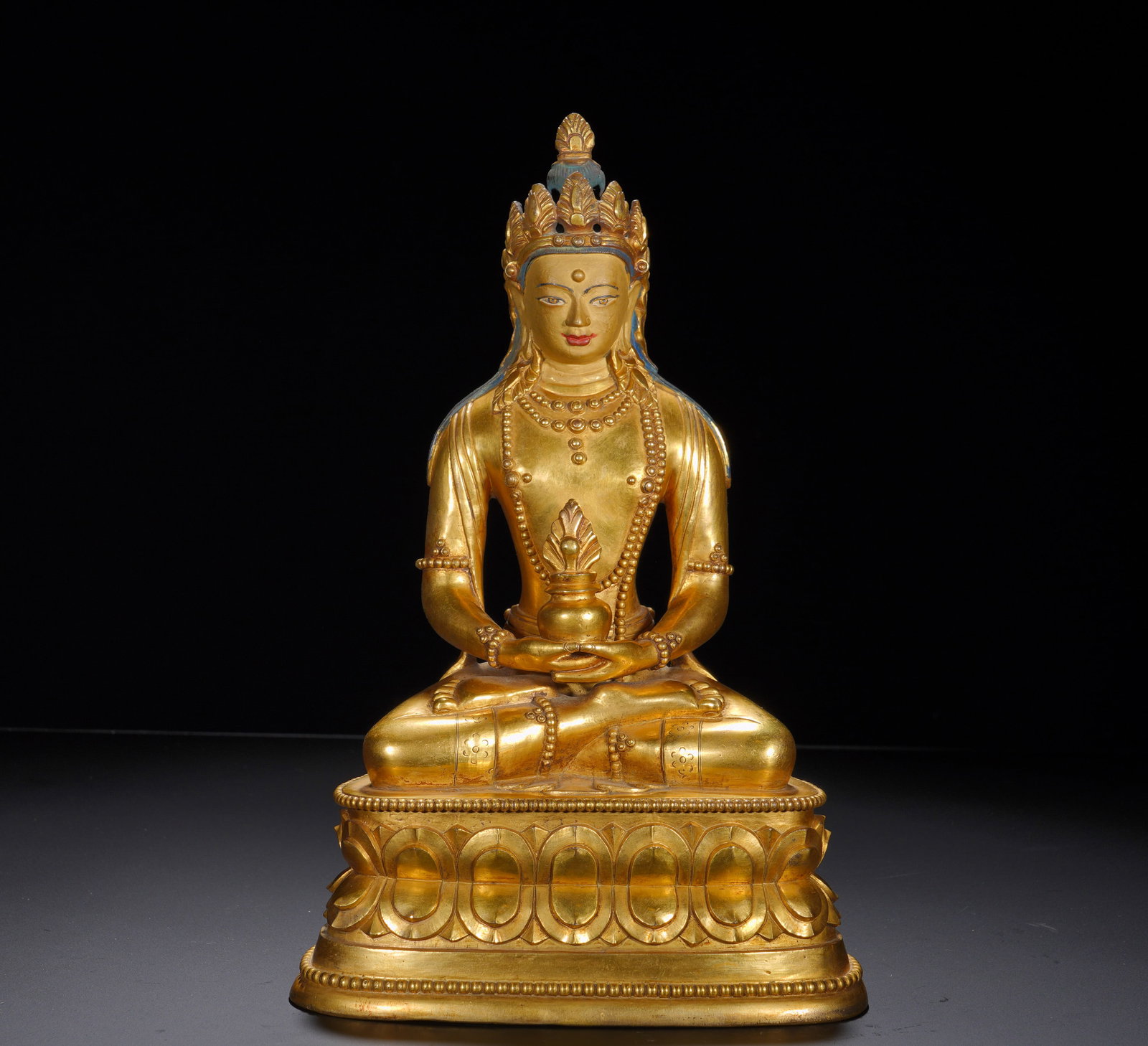 A GILDED BRONZE SITTING STATUE OF THE BUDDHA OF INFINITE LIFE FROM THE MING DYNASTY: Height: 32cm(12.60in), Width: 21cm(8.27in), Weight: 5290g (11.662lb)Amitayus symbolizes boundless lifespan, blessings and wisdom. With canonical iconography and balanced proportions, the work carries 
