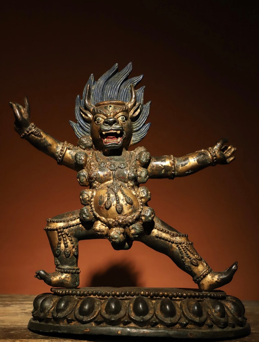 A GILDED BRONZE VAJRA STATUE FROM THE MING DYNASTY: Weight: 5600gH: 37cmL: 32cmW: 17cmThis is a Tibetan Buddhist gilt-bronze statue of a wrathful protector, depicted in a standing posture with a fierce face, protruding fangs, a flame-shaped halo on the