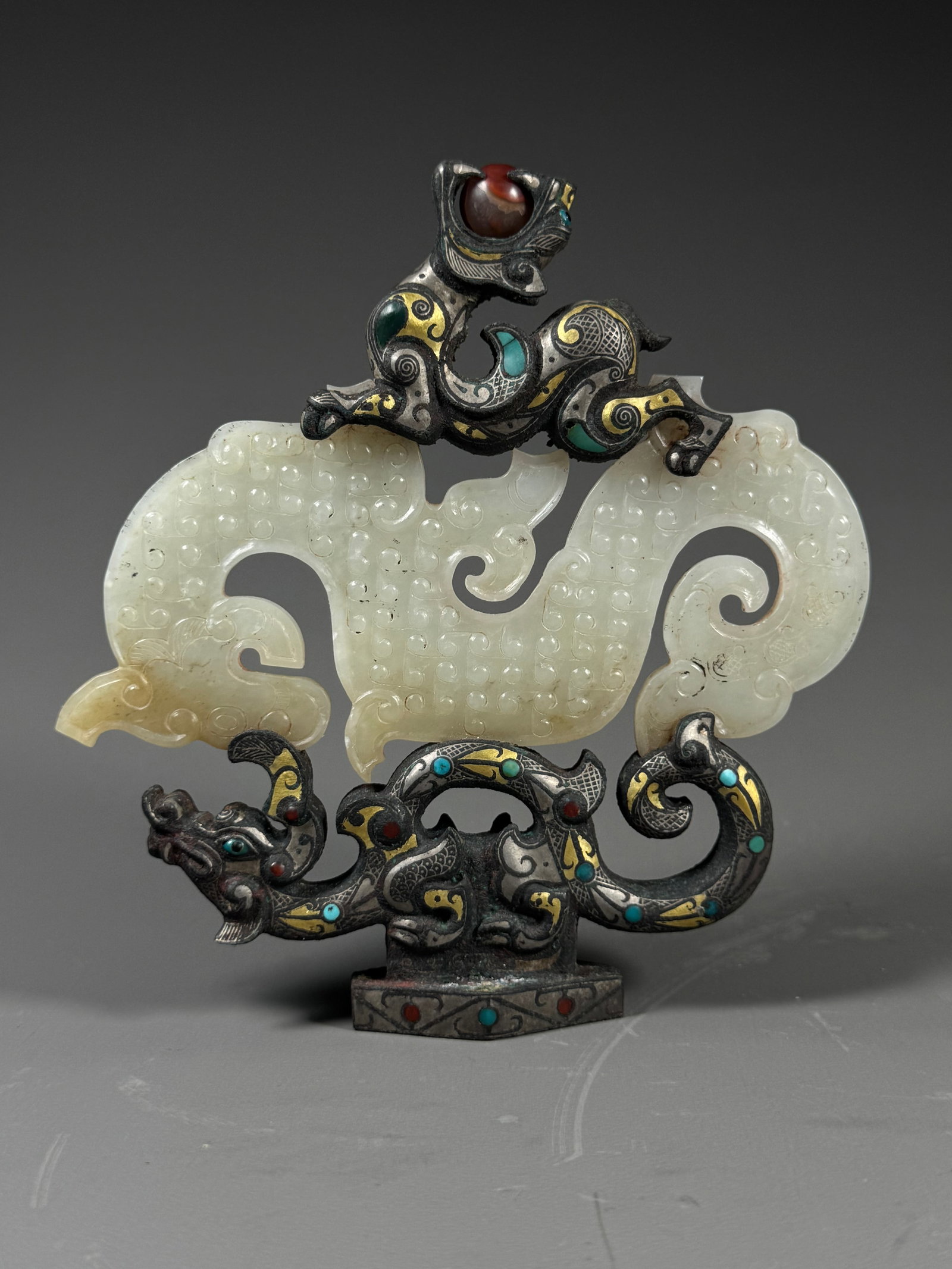 WARRING STATES PERIOD WHITE JADE S-SHAPED DRAGON WITH GOLD AND SILVER INLAID TREASURE COPPER DRAGON: Height: 15cm(5.91in), Width: 14cm(5.51in), Weight: 571g (1.259lb)Warring States S-shaped White Jade Dragon Pendant with Gold & Silver Inlaid Gem-set Bronze Dragon StandThe main piece is a Warring Stat