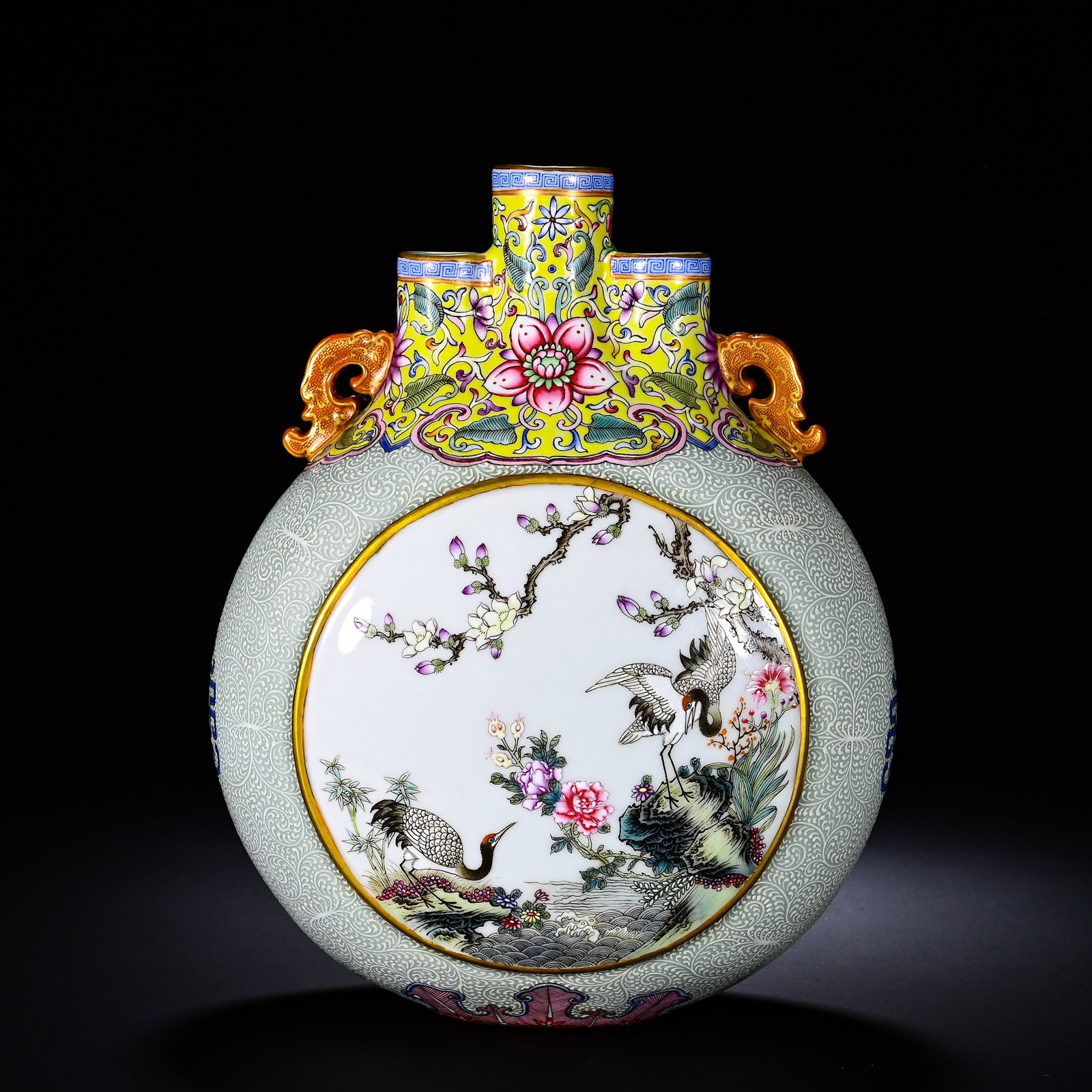 A FLAT BOTTLE OF THE QIANLONG PERIOD OF THE QING DYNASTY, WITH A PADPADERED AND POLISHED DESIGN: Height: 20cm(7.87in), Diameter: 17cm(6.69in)This is a Qianlong?period famille?rose flat five?tube vase with dragon?shaped gilded handles. Its neck is decorated with scrolling flowers on yellow ground.