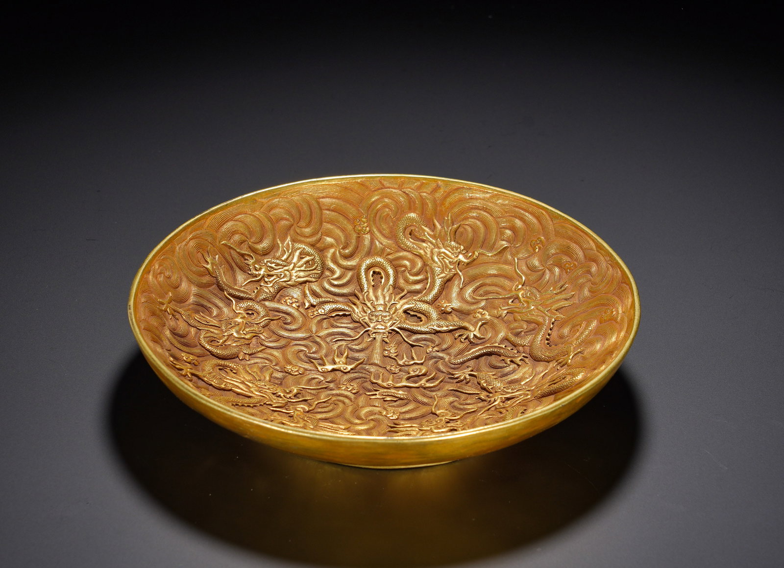 TANG DYNASTY GILDED COPPER PLATE WITH PATTERNS OF DRAGONS FIGHTING OVER THE SEA: Height: 4cm(1.57in), Diameter: 20.5cm(8.07in), Weight: 820g (1.808lb)The dragon represents supreme auspicious power; a gathering of dragons symbolises prosperity, peace across the realm and imperial p