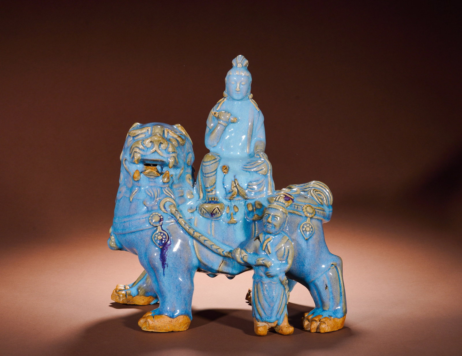 A PORCELAIN FIGURE OF MANJUSRI BODHISATTVA RIDING A LION IN SKY BLUE GLAZE FROM JUN KILN OF THE YUAN: Height: 36cm(14.17in), Width: 33cm(12.99in), Weight: 6710g (14.793lb)This grouped porcelain sculpture is a large Buddhist figurine from the Jun kiln system of the Yuan Dynasty. It depicts Manjushri Bo