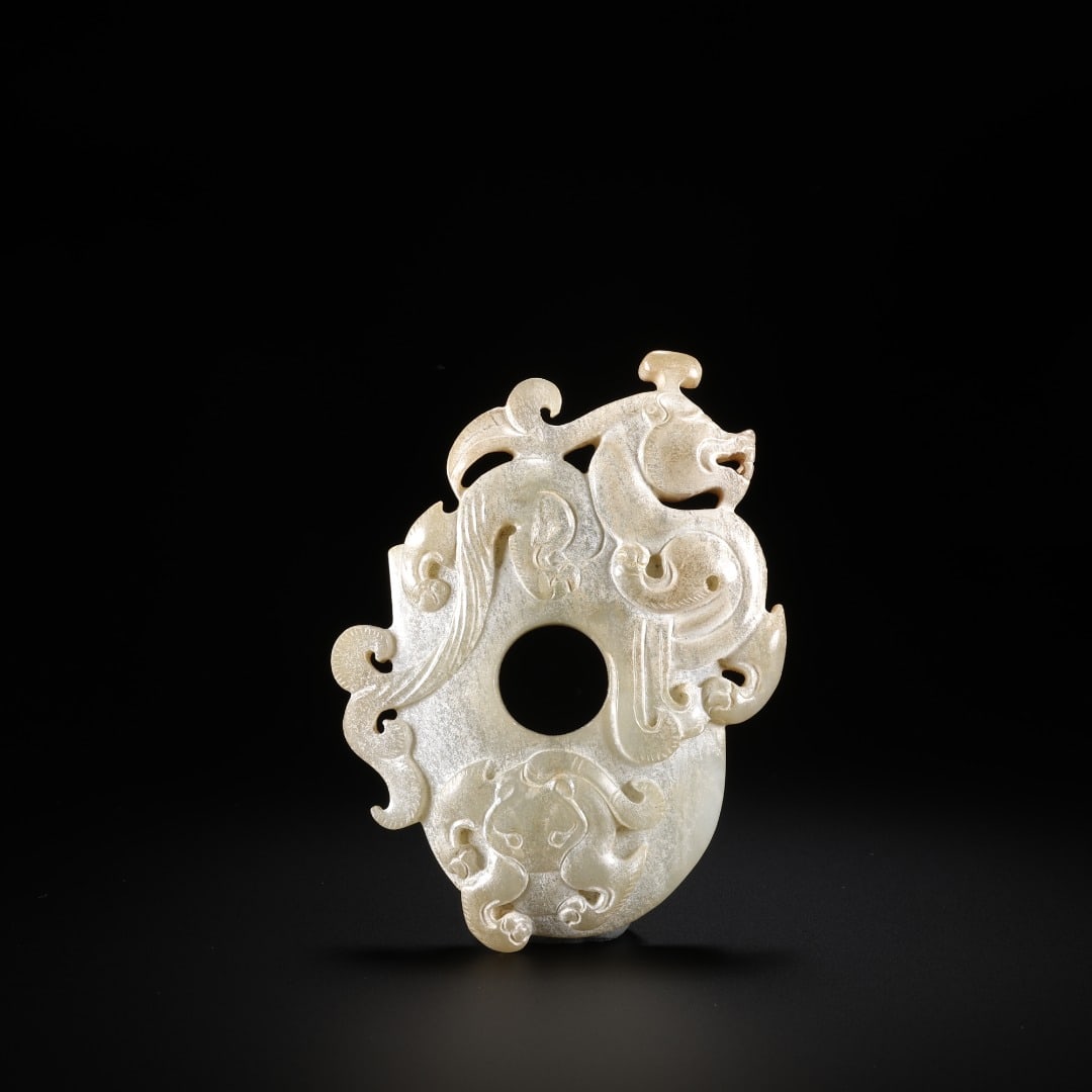 HAN DYNASTY JADE PENDANT WITH DRAGON AND PHOENIX PATTERNS ?s SHAPED PENDANT (CHICKEN HEART PENDANT): Length: 8.3cm(3.27in), Width: 5.5cm(2.17in), Thickness: 1.2cm(0.47in), Weight: 67g(0.148lb)Carved from a single piece of Hetian jade, this pendant retains the central circular aperture of the ancient 