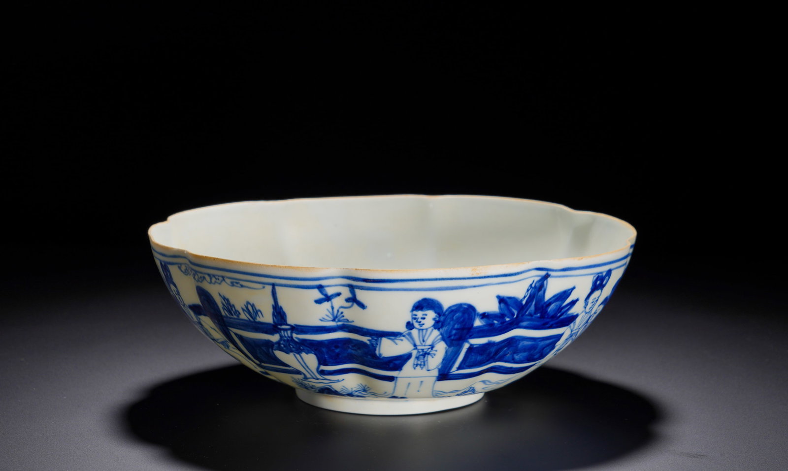 A BOWL BESTOWED BY WAN GUIFEI, A BLUE AND WHITE LADY OF CHENGHUA IN THE MING DYNASTY: Height: 24.3cmWidth: 7.5cmWeight: 280gBlue and white flower-rim bowl decorated with court ladies in garden scene. The base bears a long vertical inscription recording it was an imperial gift for Noble