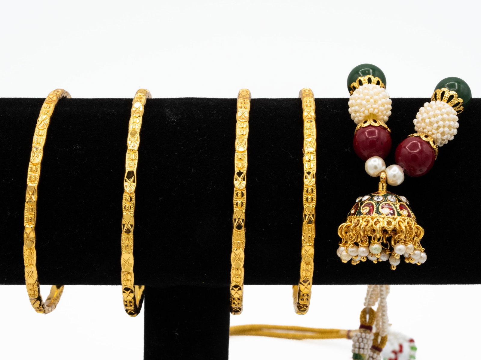 Gold-Tone Bangles & Indian Necklace Lot: Fashion jewelry lot: four matching gold-tone textured bangle bracelets, each about 6.5 inches circumference, plus one traditional Indian-style multi-strand necklace with white seed beads, green and re