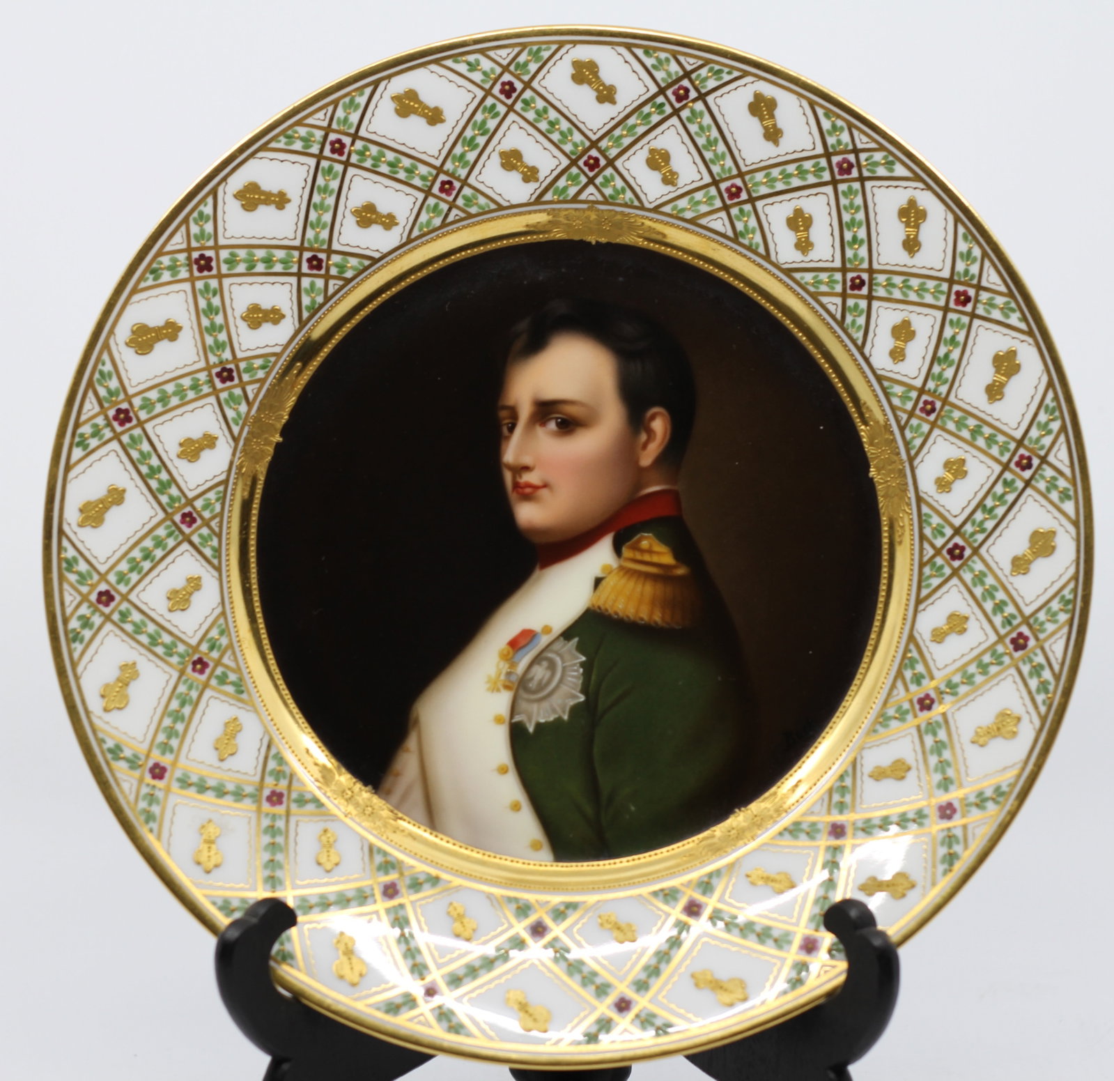 Exceptional Antique Hand Painted Royal Vienna Porcelain Plate of Napoleon: A fine European hand-painted porcelain cabinet plate depicting Napoleon Bonaparte in imperial military uniform with Legion of Honor decoration. The central portrait is surrounded by an elaborate gilt 