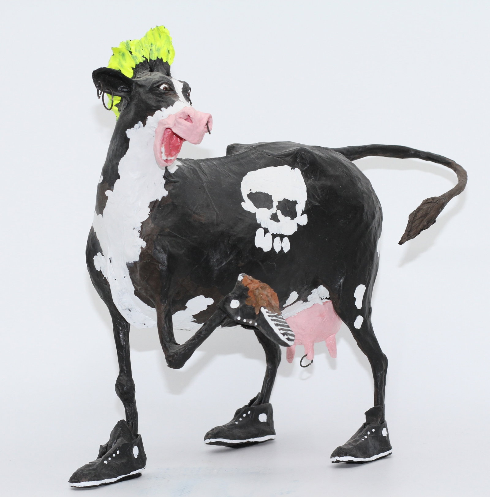 Punk Rock Anarchy Cow, Contemporary Folk Art Punk Cow Sculpture with Skull Motifs: Whimsical mixed-media folk art sculpture depicting a black-and-white cow styled with a neon yellow-green mohawk, multiple hoop earrings, skull decorations, black sneakers, and an exaggerated open-mout