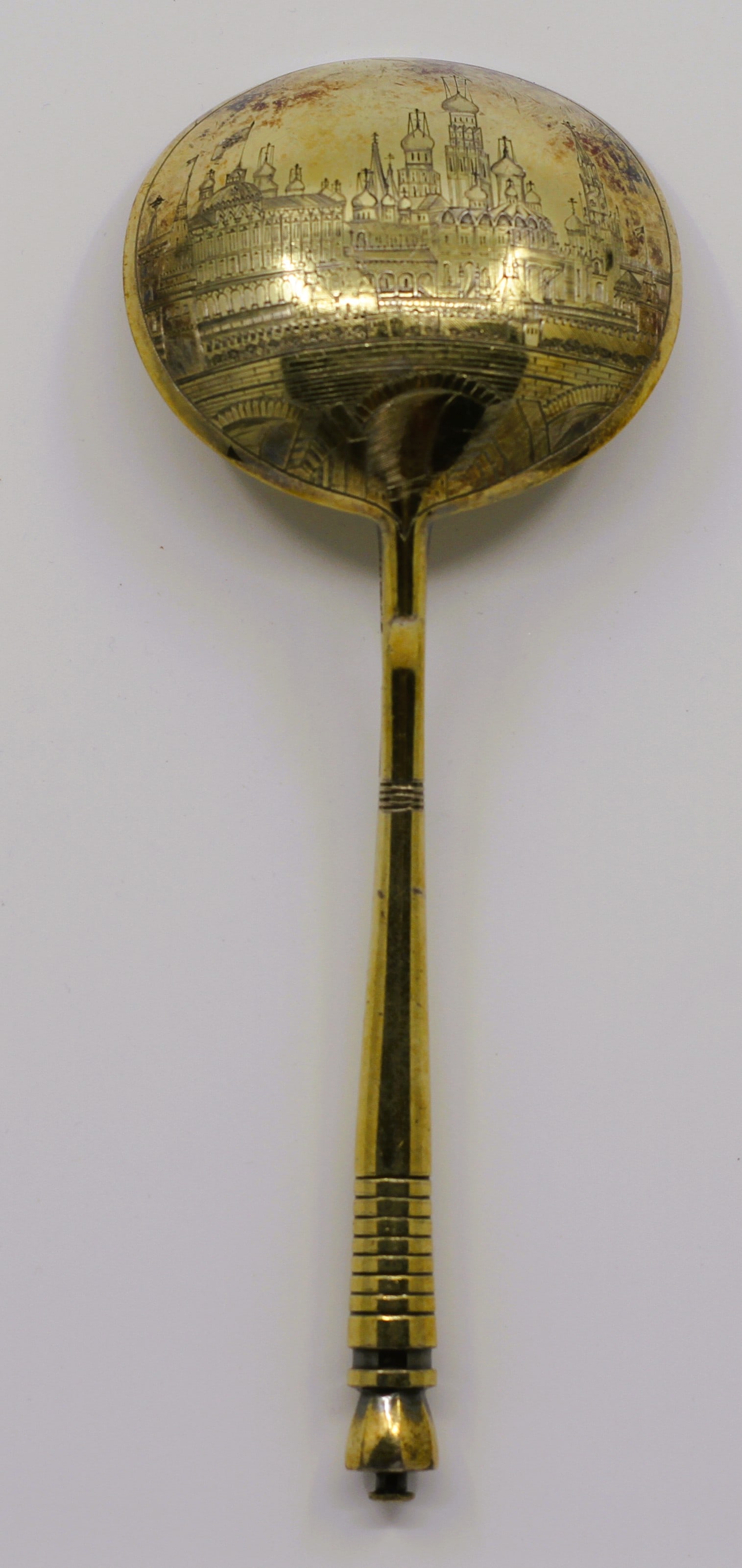 Imperial Russian Silver-Gilt & Niello Serving Spoon: An exceptional 19th-century Imperial Russian 84 zolotnik silver-gilt and niello serving spoon. The reverse of the deep teardrop bowl features an exceptionally detailed, hand-engraved niello panoramic 