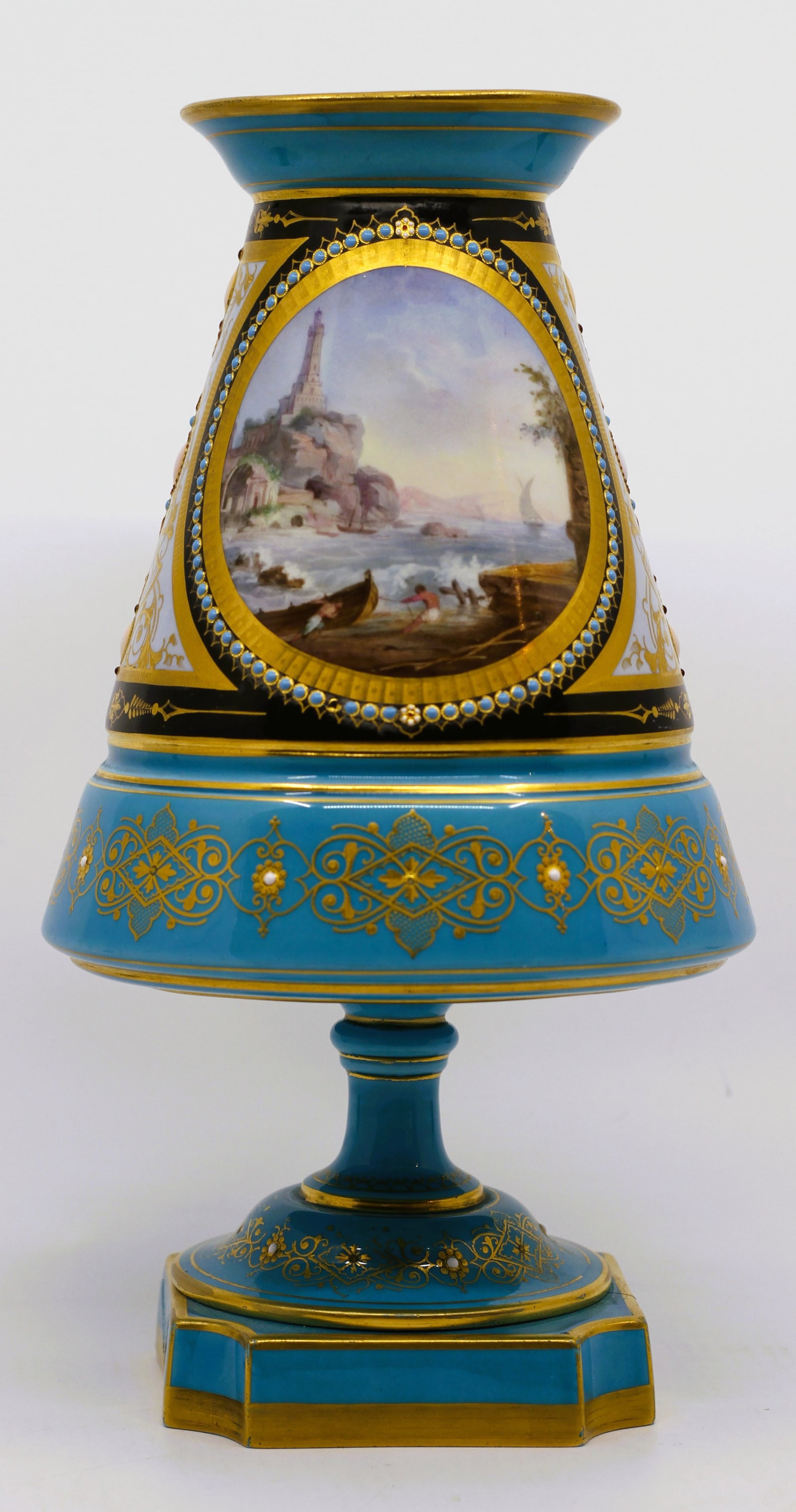 Large French Sevres-Style Gilt Porcelain Scenic Vase: Large pedestal porcelain vase in turquoise blue with extensive gilt decoration, black and white reserve panels, and raised enamel-style jeweled accents. One side features a painted coastal landscape w