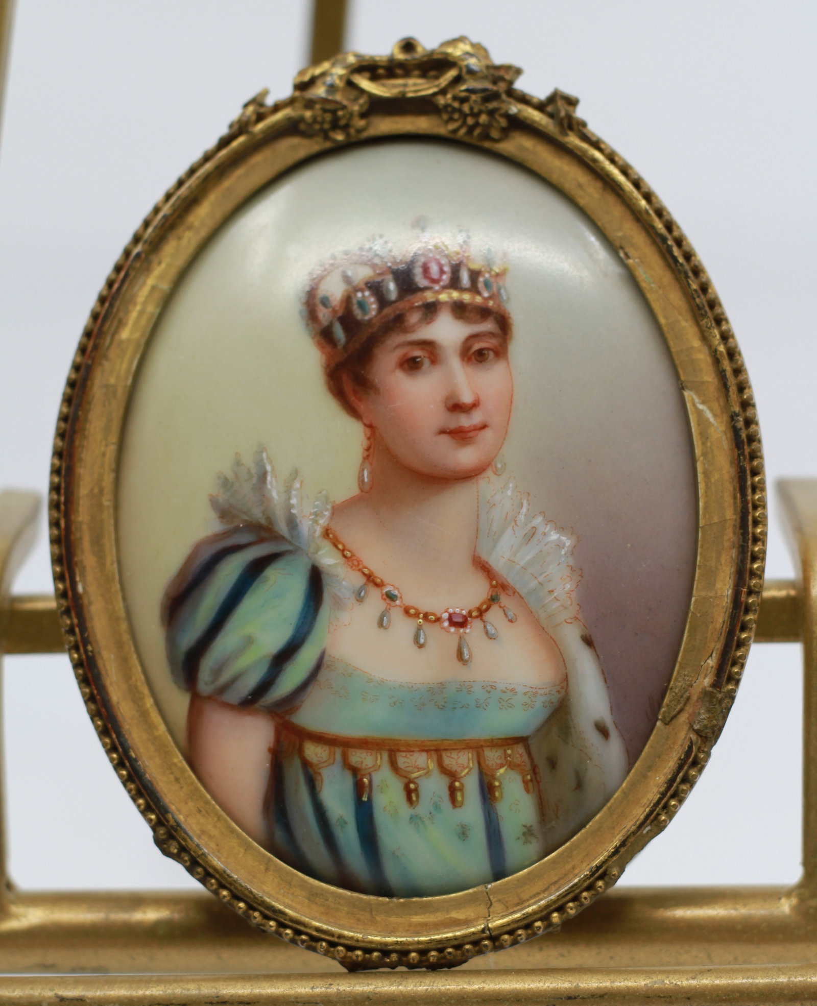Antique Porcelain Portrait Plaque of Empress Josephine: Antique oval porcelain portrait plaque depicting Empress Josephine de Beauharnais wearing an imperial crown and jeweled court dress. Finely hand painted and mounted in an ornate gilt frame with decora