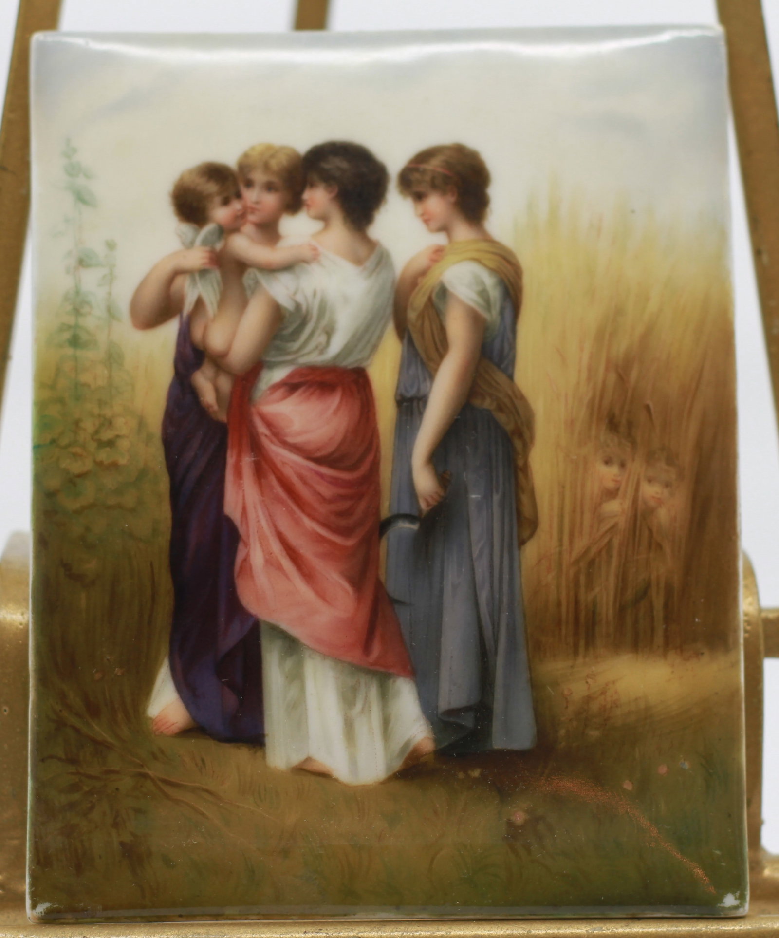 German Painting On Porcelain, Three Ladies And Baby Ca. 1900: Decorative rectangular porcelain plaque finely hand painted with a neoclassical pastoral scene depicting three women, a child, and two children partially hidden among tall grasses. Softly modeled figu