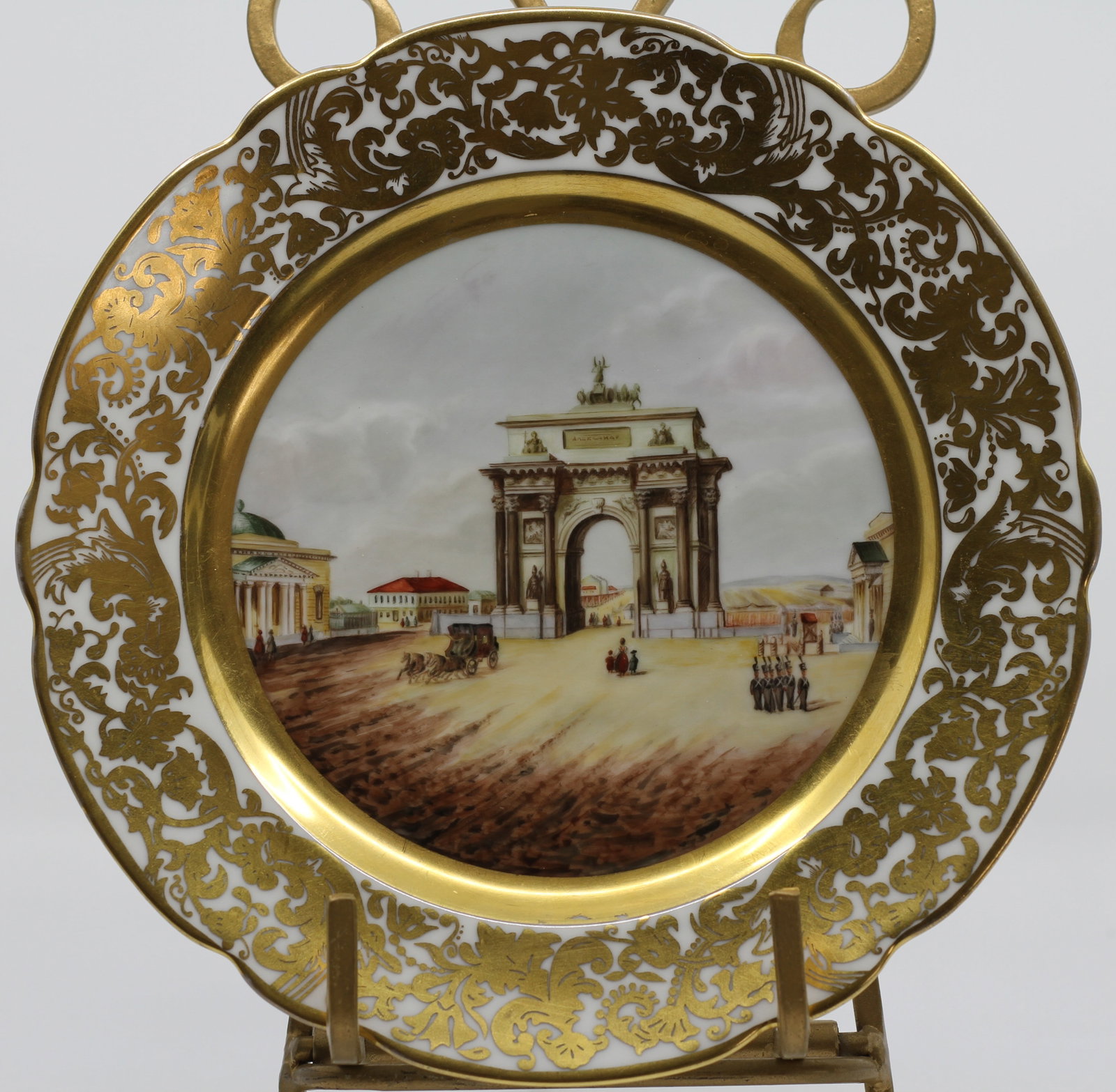 Russian Kuznetsov Porcelain Scenic Gilt Plate: Antique Russian porcelain plate by Kuznetsov Moscow. Hand painted architectural city scene with figures and carriage, surrounded by an elaborate gilt floral border. Green factory mark to reverse.