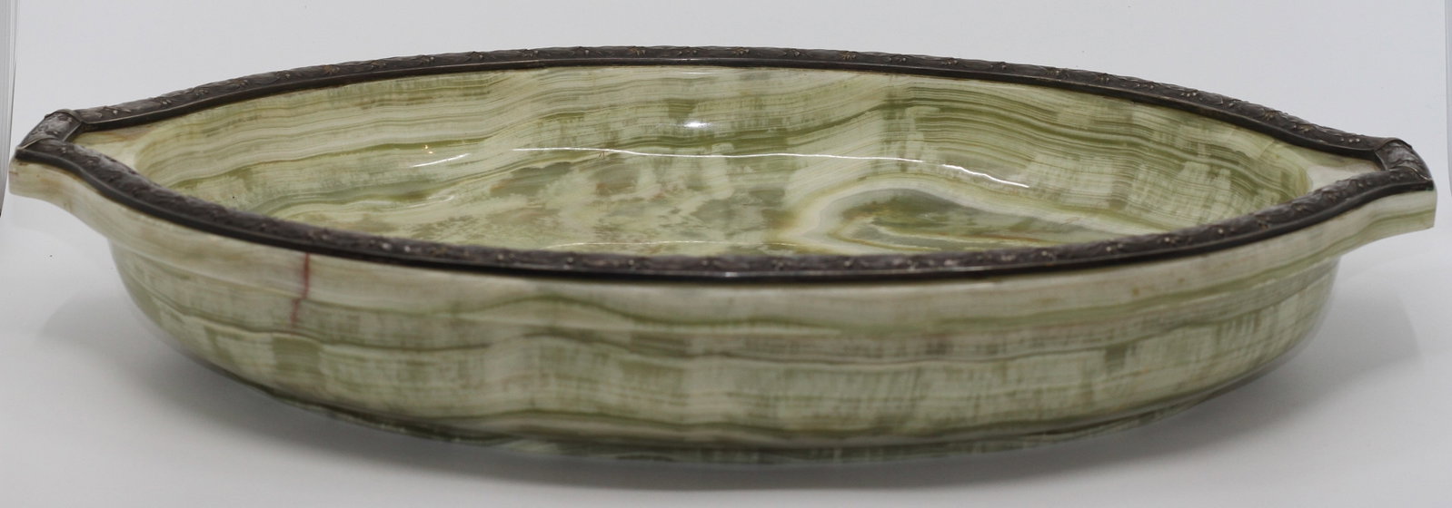 BOLIN RUSSIAN ONYX TAZZA WITH SILVER RIM: Russian carved pale green banded onyx tazza or shallow dish mounted with a finely worked silver rim decorated with foliate motifs. The shaped oval body displays attractive natural striations