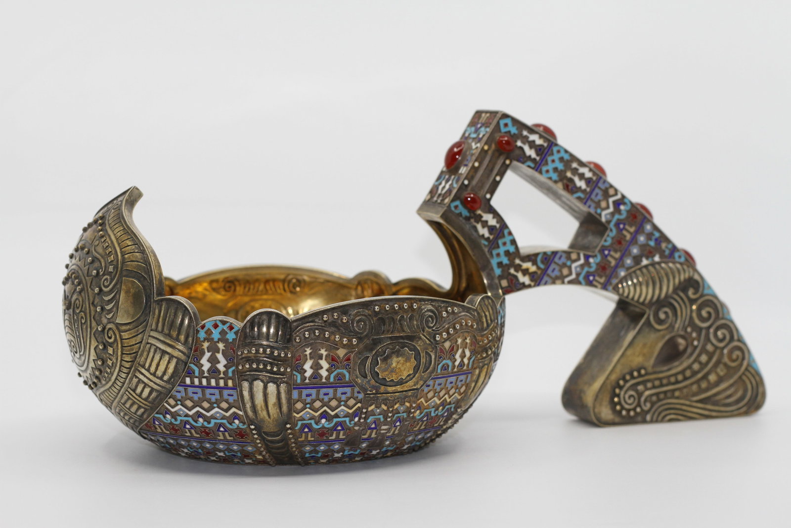 Large Russian 84 Silver Cloisonne Enamel Kovsh: Ornate Russian style silver kovsh with extensive polychrome cloisonne enamel decoration in turquoise, blue, red, and white. Raised geometric and foliate motifs with red cabochon accents to the tall ar