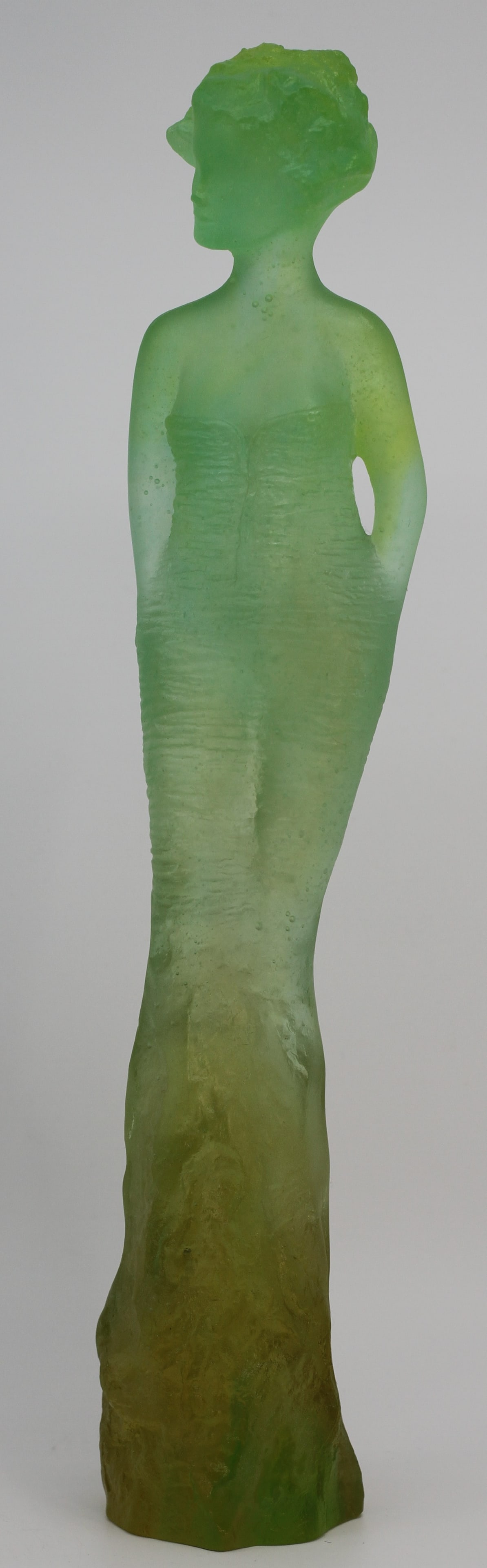 Daum France Pate de Verre Green Female Figure Sculpture: Daum France pate de verre glass sculpture depicting a stylized standing female figure in an elongated gown. Graduated green and olive coloration with textured surface and translucent finish.