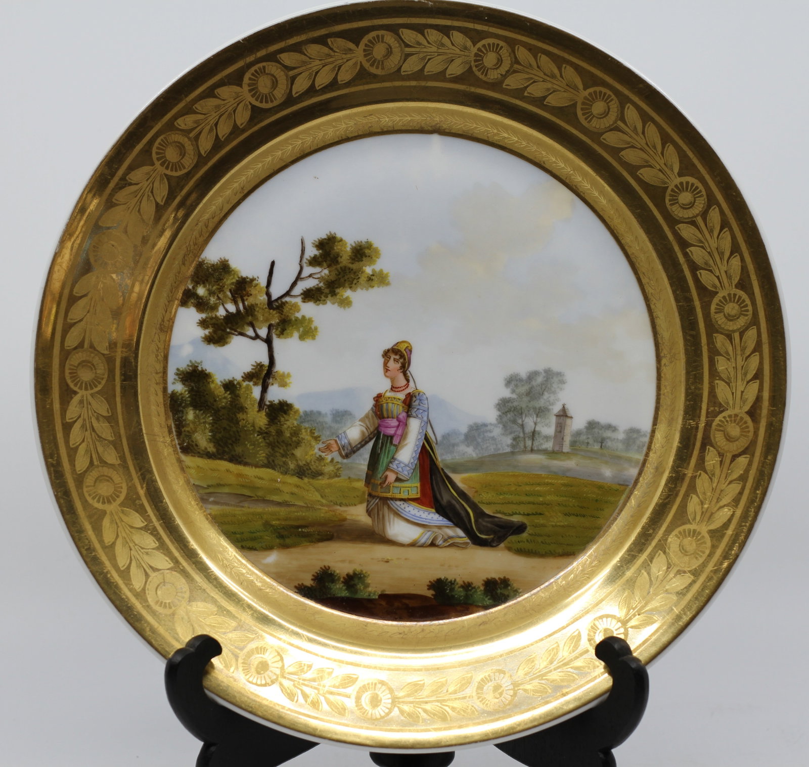 Denuelle Paris Porcelain Cabinet Plate, "Femme de Carafa," Costume Study: A French porcelain cabinet plate retailed by Denuelle, Rue de Crussol, Paris, the center finely hand-painted with a full-length figure of a woman in regional Italian costume (identified on the reverse