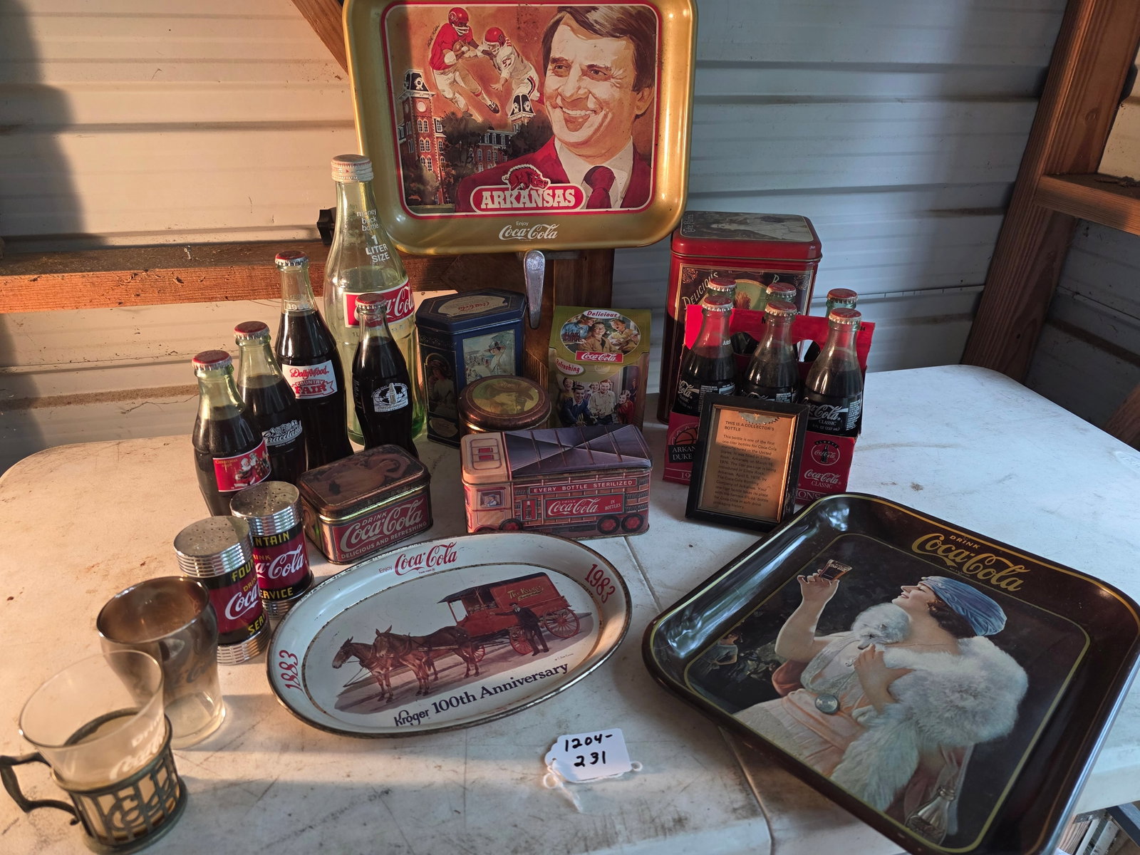 Coca-Cola bundle: coca-cola metal trays; tins; small framed history; filled bottles of Coke collectors editions; salt and pepper shakers and a couple small glasses
