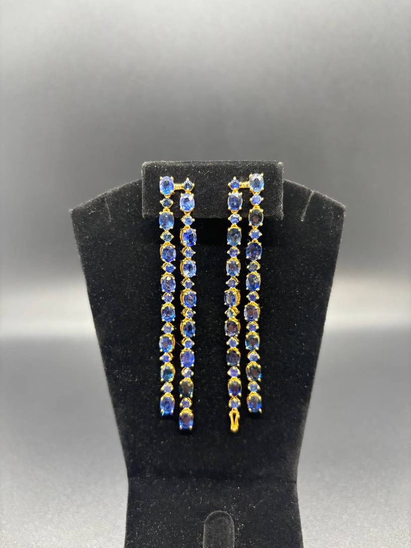 18KT Gold Blue Sapphire Drop Earrings: Stunning custom-made 18KT yellow gold drop earrings set with a total of 62 blue sapphires. A rare and elegant pair crafted with exceptional detail, featuring a beautiful combination of oval and round