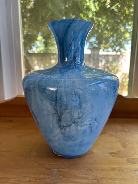 Blue Vase: This selected item is a beautiful art glass vase featuring a marbled sky-blue and white pattern with a unique cracked or webbed design and a smooth, polished neck.