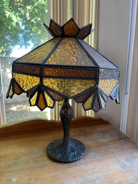 Tiffany Style Lamp: This 14" Tiffany-style table lamp features a handcrafted, multi-tone amber and brown slag glass shade in a geometric crown pattern, supported by an ornate vintage-style cast metal base.