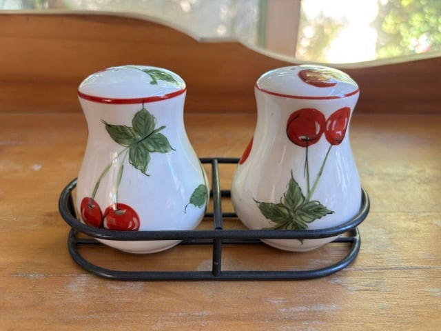 Cherry Salt and Pepper Shaker: These are "Cherries Jubilee" ceramic salt and pepper shakers. GoThe white porcelain set features hand-painted cherries and green leaves, and sits in a convenient black wire metal holder.