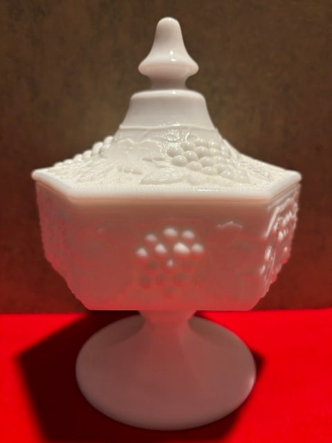 Imperial grape pattern milk glass compote: This is a vintage Imperial Glass compote, likely from the 1951–1970 era.It is crafted from white milk glass with a "DoeSkin" or satin finish.The piece features a distinct hexagon shape decorated wit
