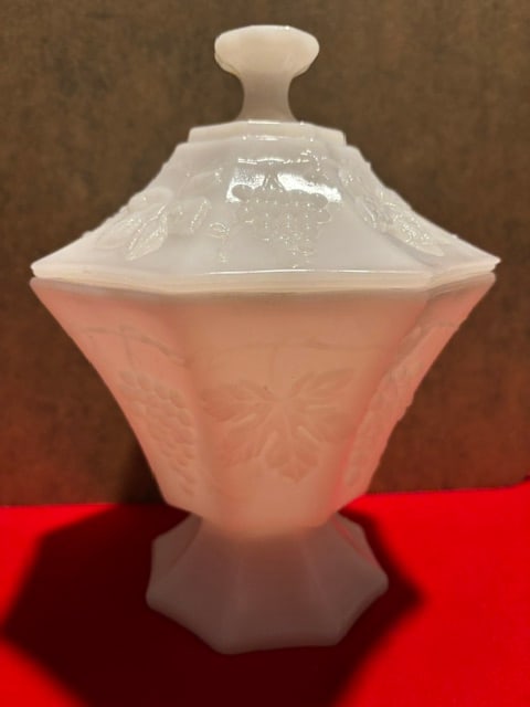 Vintage Anchor Hocking Milk Glass Pedestal Harvest Grape Covered Candy Dish: Vintage milk glass covered candy dish with an embossed grape design. The dish is in the shape of an octagonwith 8 panels.No chips or cracks.7 3/4 inches tall and 5 1/2 inches wide at the widest. 1