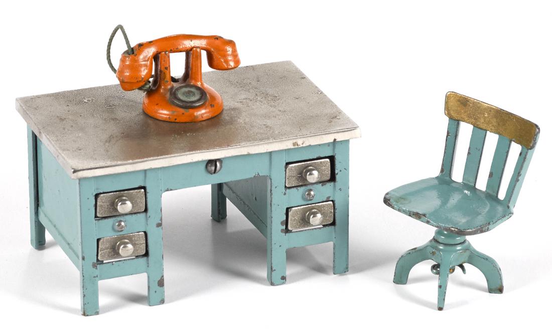 Kenton cast iron blue knee hole desk, 2 3/4'' h., with: Kenton cast iron blue knee hole desk, 2 3/4'' h., with a telephone and a swivel chair.