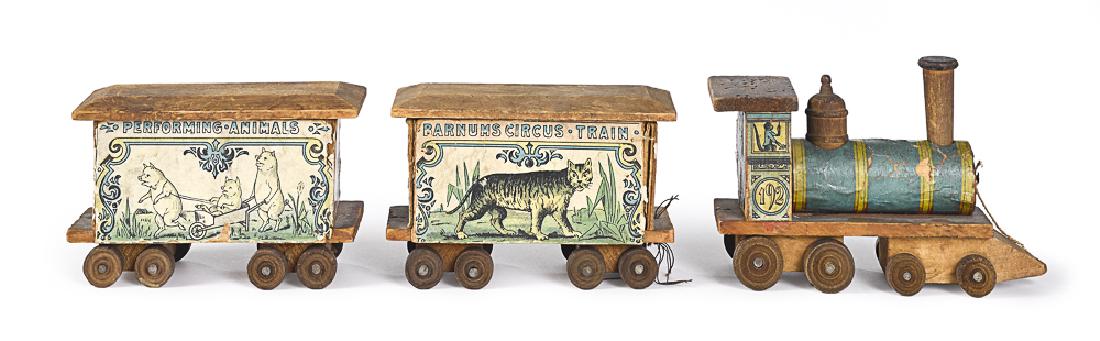 Barnum's paper lithograph over wood circus train: Barnum's paper lithograph over wood three-piece circus train, to include no. 192 locomotive, Performing Animals car and a Barnums Circus Train car, engine - 6 1/2'' l.