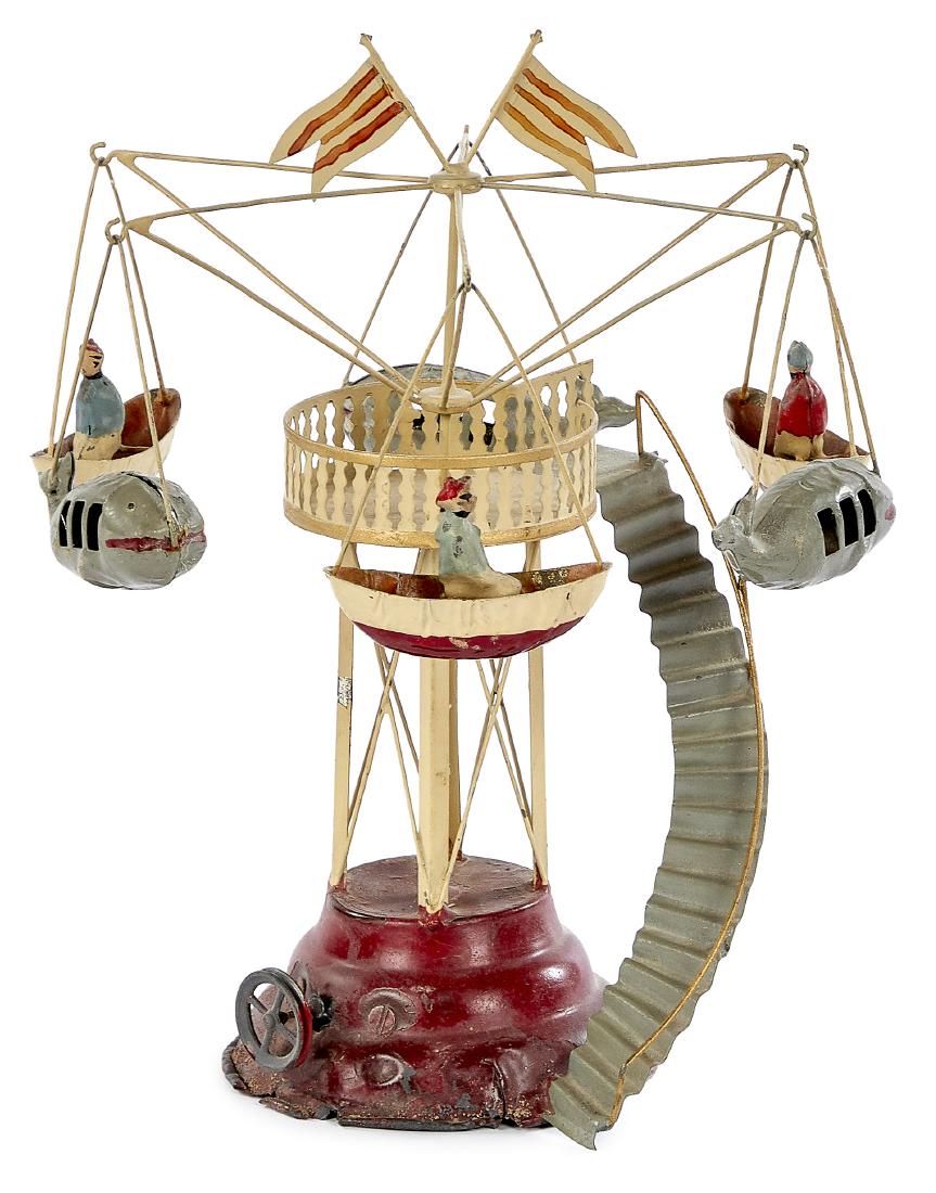 Carette painted tin carousel steam toy accessory: Carette painted tin carousel steam toy accessory #138/5, with three painted tin riders in boats, three unusual alternating whale form gondolas, and a circular staircase, 10 1/4'' h. Pictured in Morton