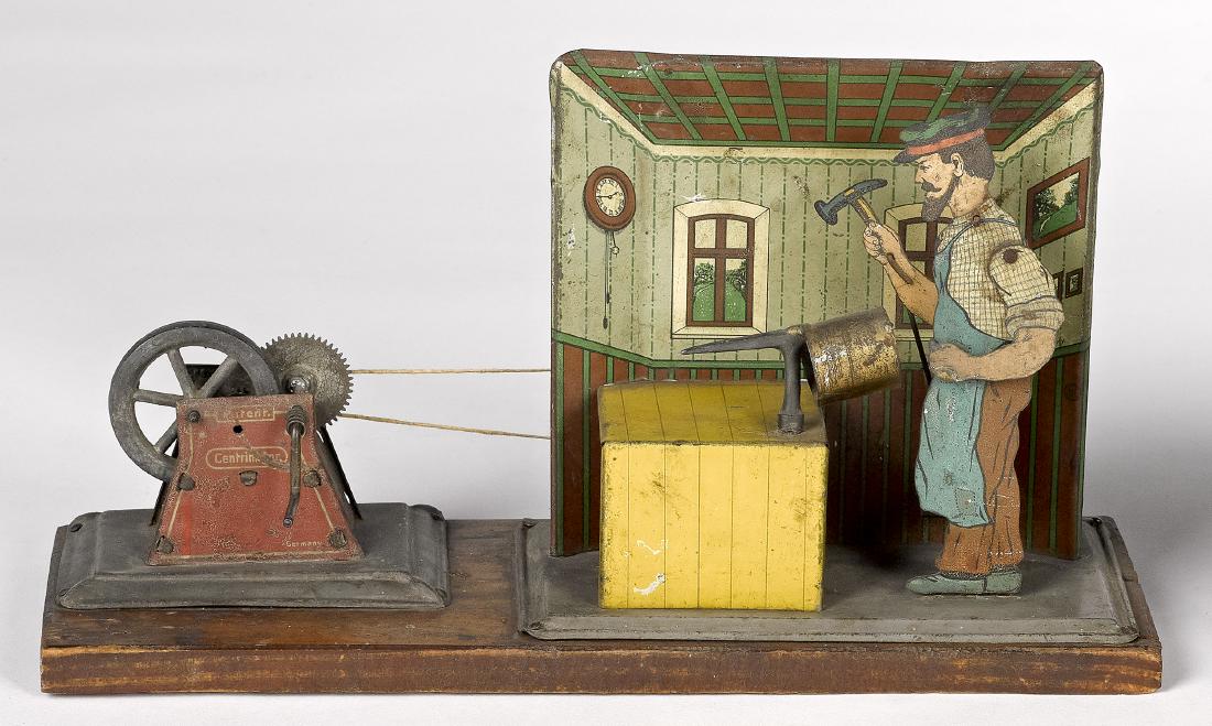 Mohr & Krauss tinsmith steam toy accessory: Mohr & Krauss tin lithograph tinsmith steam toy accessory, with hand cranked central motor drive on wood base, 5'' h., 10'' w., 4'' d. Pictured in Morton A. Hirschberg Steam Toys - A Symphony in Motio