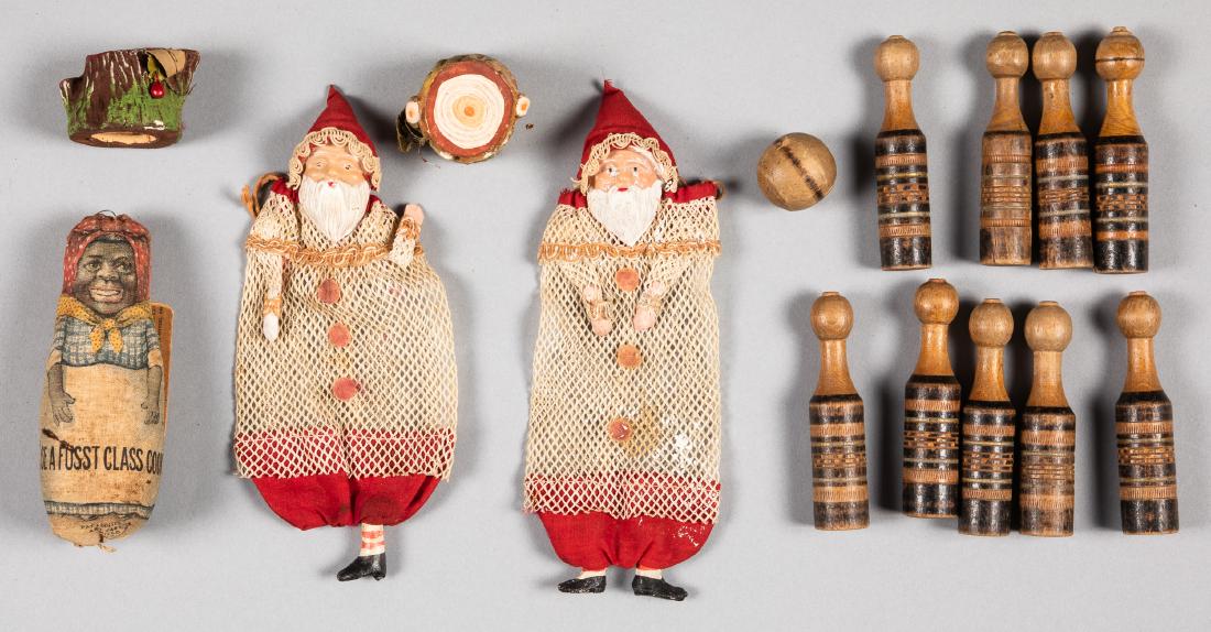Miscellaneous toys and holiday items: Miscellaneous toys and holiday items, to include two composition tree stump candy containers, two mesh Santa Claus candy bags, a cloth black mammy souvenir doll, and eight carved and painted skittles 