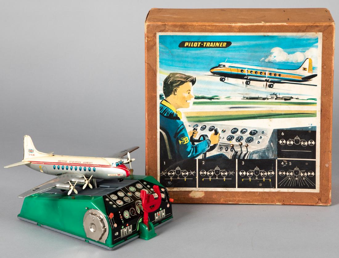 German tin lithograph Pilot Trainer: German tin lithograph battery operated Pilot Trainer, with the original box, the airplane is on a treadmill with responds to levers, 11'' wingspan. Provenance: Estate of Jonathan Barrow, Los Angeles, 