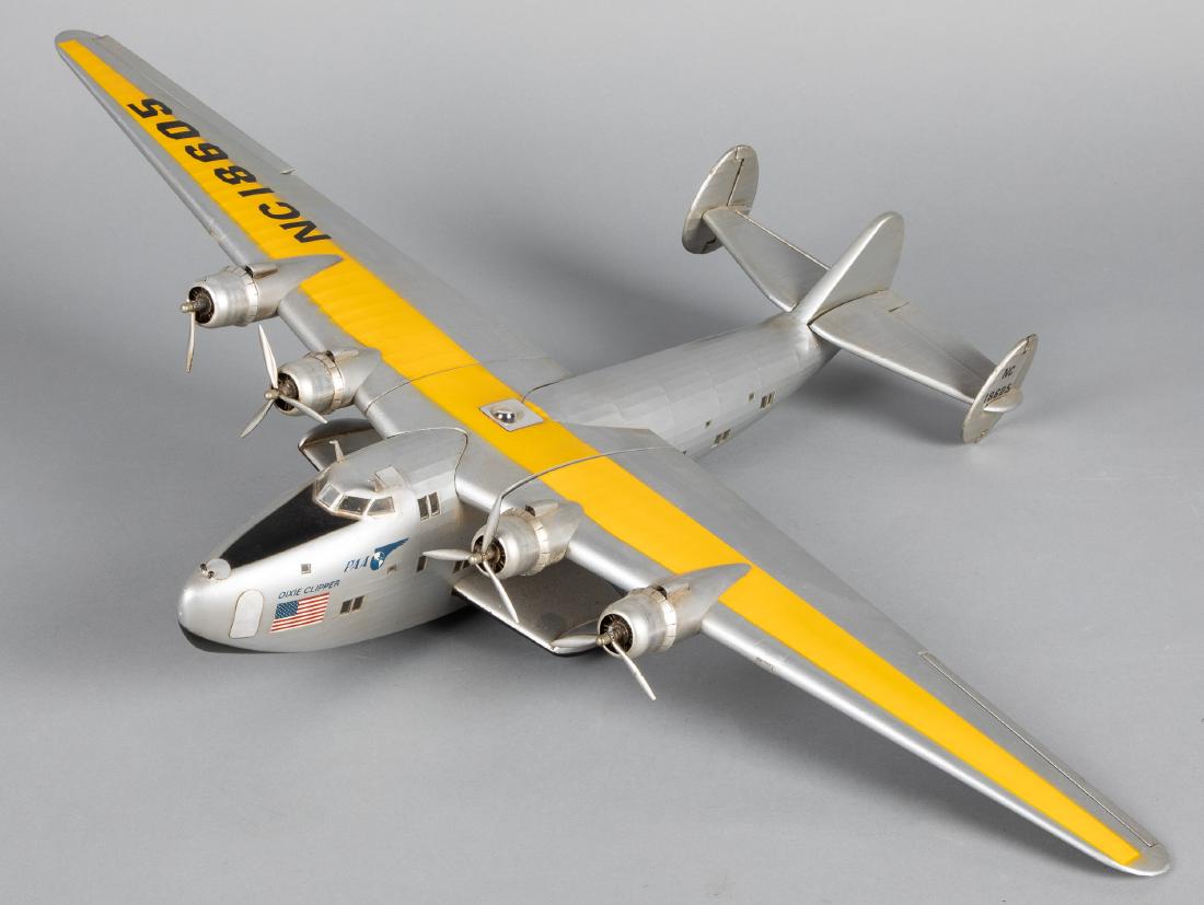 Contemporary Pan American Dixie Clipper airplane: Contemporary Pan American Dixie Clipper wood and metallic fabric airplane model, 32'' wingspan. Provenance: Estate of Jonathan Barrow, Los Angeles, California.