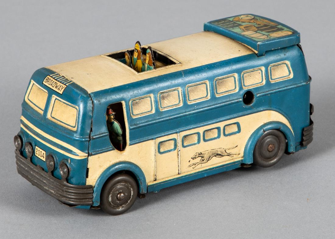 Joustra tin lithograph wind-up Greyhound bus: Joustra tin lithograph wind-up Greyhound bus, with pop-out driver and passengers, 5 1/2'' l. Provenance: Estate of Jonathan Barrow, Los Angeles, California.