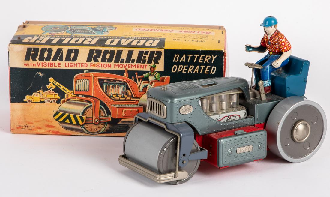 Japanese Showa tin lithograph road roller: Japanese Showa tin lithograph battery operated road roller, with the original box, having a farmer driver and viable lighted piston engine movement, 10 1/2'' l. Provenance: Estate of Jonathan Barrow, 