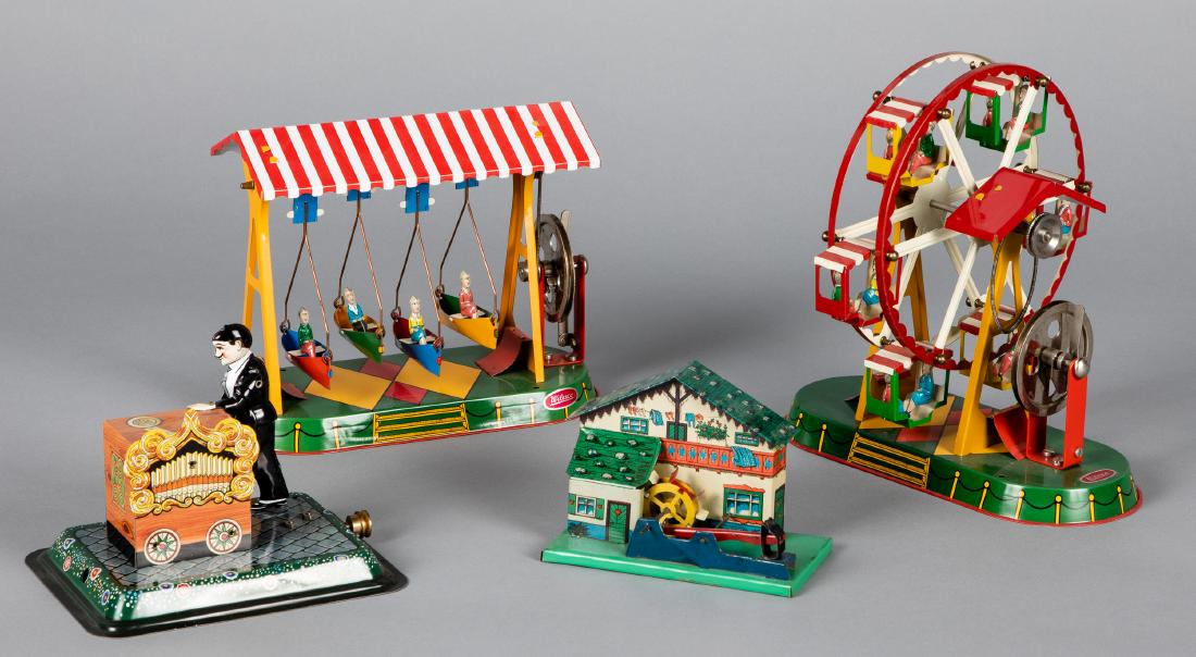 Four Wilesco tin lithograph steam toy accessories: Four Wilesco tin lithograph steam toy accessories, to include a carousel, swinging boats, an organ grinder, and a mill with waterwheel, tallest - 9''. Provenance: Morton A. Hirschberg.