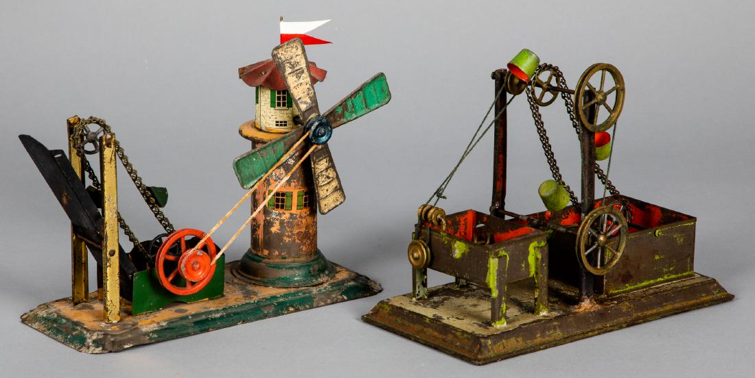 Two painted tin dredge steam toy accessories: Two painted tin dredge steam toy accessories, to include one Carette 7 '' h., the other with windmill, 7 1/2'' h. Crette Pictured in Morton A. Hirschberg Steam Toys - A Symphony in Motion, page 83. Pr