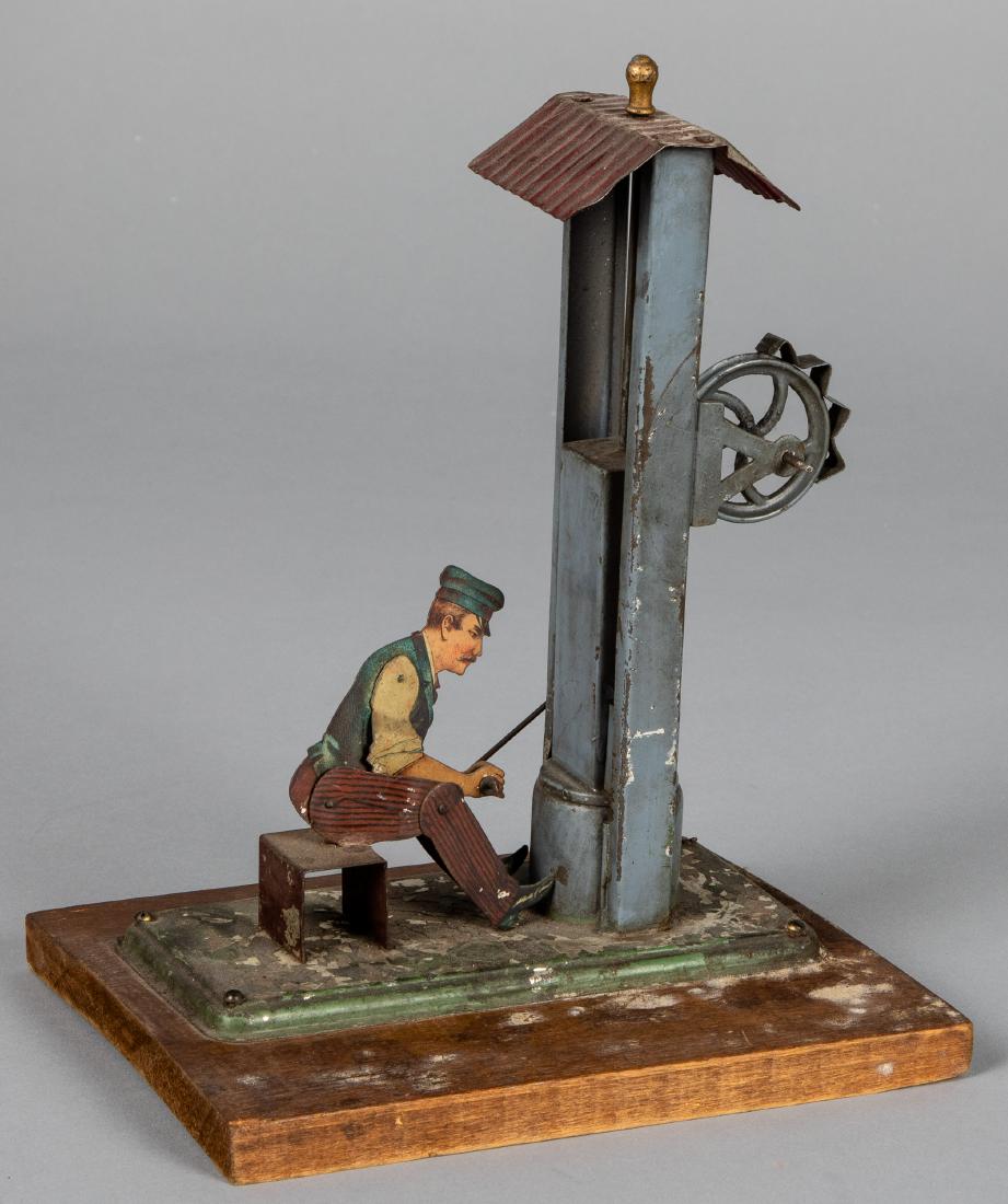 Bing lithograph tin smith at drop press steam toy: Bing lithograph tin smith at drop press steam toy accessory, #9956/359, mounted to a wood base, 9 1/2'' h. Pictured in Morton A. Hirschberg Steam Toys - A Symphony in Motion, page 52. Provenance: Mort