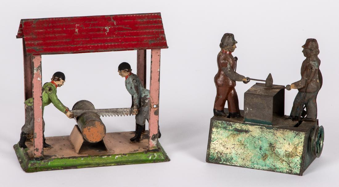 Two painted tin workmen steam toy accessories: Two painted tin workmen steam toy accessories, to include two blacksmiths at an anvil, probably Bing, and two sawyers under a roof, tallest - 5 3/4''. Pictured in Morton A. Hirschberg Steam Toys - A S