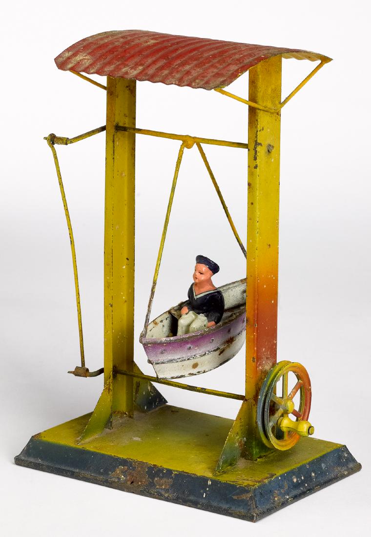 Painted tin rocking ship steam toy accessory: Painted tin rocking ship steam toy accessory, with a sailor seated in a boat, 7'' h. Provenance: Morton A. Hirschberg Steam Toy Collection