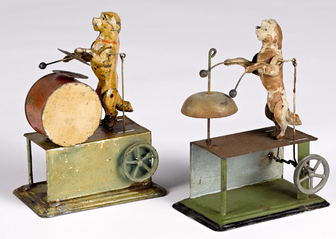 Two dog steam toy accessories: Bing painted tin dog playing a drum steam toy accessory, 6 1/4'' h., together with a dog playing the bell, 6 1/4'' h. Pictured in Morton A. Hirschberg Steam Toys - A Symphony in Motion, page 66. Prove